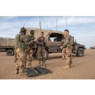 Des soldats montent l'antenne d'un véhicule léger de reconnaissance et d'appui (VLRA) moyen d’élongation pour les communications hautes fréquences interarmées et OTAN en réseau (MELCHIOR) pour installer un centre opérationnel (CO) sur l'axe Berliet, au Niger.