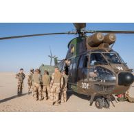 Des soldats du 1er régiment de chasseurs (RCh) déchargent une boîte de vitesse pour véhicule léger de reconnaissance et d'appui (VLRA) depuis un hélicoptère Puma SA-330B sur l'axe Berliet, au Niger.