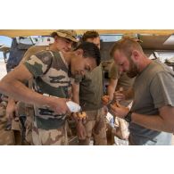Des soldats du 1er régiment de chasseurs (RCh) confectionnent des beignets pour le repas des troupes lors d'un bivouac sur l'axe Berliet, au Niger.