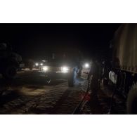 Un logisticien du Service des essences des armées (SEA) ravitaille un véhicule léger de reconnaissance et d'appui (VLRA) en carburant lors de l'arrêt nocturne d'un convoi sur l'axe Berliet, au Niger.