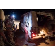 Un logisticien du Service des essences des armées (SEA) ravitaille un véhicule Peugeot P4 lors de l'arrêt nocturne d'un convoi sur l'axe Berliet, au Niger.