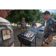 Des instructeurs du 1er régiment de chasseurs (RCh) préparent le barbecue pour la visite de leur chef de corps à Loumia, au Tchad.