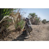 Un élève officier tchadien observe le périmètre pour un déplacement en binôme à Loumia, au Tchad.