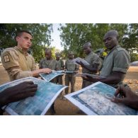 Un instructeur du 1er régiment de chasseurs (RCh) montre comment faire un azimut au moyen d'une boussole auprès d'élèves officiers tchadiens à Loumia, au Tchad.