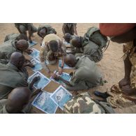 Un instructeur du 1er régiment de chasseurs (RCh) montre comment faire un azimut au moyen d'une boussole auprès d'élèves officiers tchadiens à Loumia, au Tchad.
