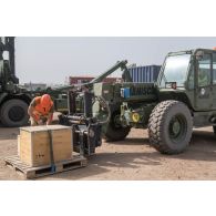 Un logisticien charge des caisses de matériel au moyen d'un chariot Manitou en zone logistique de la base aérienne de N'Djamena, au Tchad.