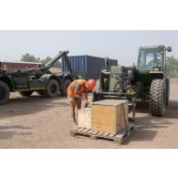 Un logisticien charge des caisses de matériel au moyen d'un chariot Manitou en zone logistique de la base aérienne de N'Djamena, au Tchad.