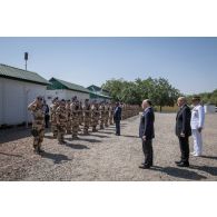 Le Premier ministre Bernard Cazeneuve passe un détachement en revue aux côtés du ministre de la Défense Jean-Yves Le Drian et du général François-Xavier de Woillemont à N'Djamena, au Tchad.