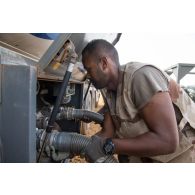 Le brigadier-chef Julien, conducteur-ravitailleur, raccorde une pompe pour le transfert du carburant livré par l'entreprise Total sur le site d'exploitation du Service des essences des armées (SEA) à Niamey, au Niger.