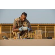 Le brigadier-chef Julien, conducteur-ravitailleur, prélève des échantillons de carburant depuis un bac souple pour les analyser au laboratoire du site d'exploitation du Service des essences des armées (SEA) à Niamey, au Niger.