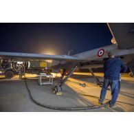 Le brigadier-chef Julien, conducteur-ravitailleur, avitaille un drone General Atomics MQ-9 Reaper de l'escadron 1/33 Belfort en carburant à Niamey, au Niger.