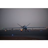Atterrissage d'un drone General Atomics MQ-9 Reaper à la tombée de la nuit à Niamey, au Niger.