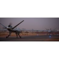 Roulage d'un drone General Atomics MQ-9 Reaper vers son hangar à la tombée de la nuit à Niamey, au Niger.