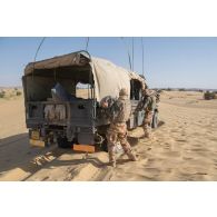 Des soldats disposent des plaques PSP pour le désensablement d'un véhicule léger de reconnaissance et d'appui (VLRA) de moyen d'élongation pour les communications HF interarmées et Otan en réseau (MELCHIOR) sur l'axe Berliet, au Niger.