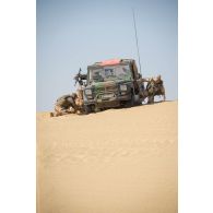 Des guideur aériens tactiques avancés (GATA) désensablent leur véhicules Peugeot P4 sur l'axe Berliet, au Niger.