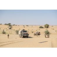 Un camion-citerne CBH-385 du Service des essences des armées (SEA) et un véhicule léger de reconnaissance et d'appui (VLRA) tentent de franchir une dune de sable sur l'axe Berliet, au Niger.