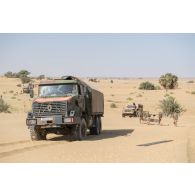 Un camion-citerne CBH-385 du Service des essences des armées (SEA) et un véhicule léger de reconnaissance et d'appui (VLRA) tentent de franchir une dune de sable sur l'axe Berliet, au Niger.