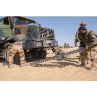 Des soldats déploient des plaques PSP pour désensabler un camion-citerne CBH-385 du Service des essences des armées (SEA) sur l'axe Berliet, au Niger.