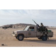 Des soldats nigériens sécurisent la route d'un convoi à bord de leur pick-up sur l'axe Berliet, au Niger.