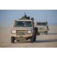 Des soldats nigériens sécurisent la route d'un convoi à bord de leurs pick-ups sur l'axe Berliet, au Niger.