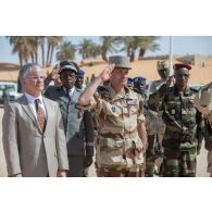 Le général François-Xavier de Woillemont salue les couleurs tchadiennes aux côtés de l'ambassadeur Philippe Lacoste à Faya-Largeau, au Tchad.