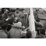 Suite à l'opération Taifun (invasion de l'île grecque de Leros), à l'aide de son micro, un officier de la compagnie de propagande réalise un reportage sur le pont d'un navire de la Kriegsmarine.