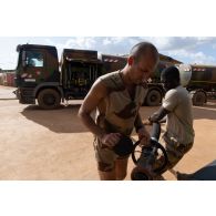 Des logisticiens du Service des essences des armées (SEA) déploient la lance de ravitaillement d'un train routier avitailleur à Gao, au Mali.