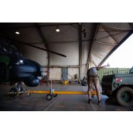 Des mécaniciens guident le retour d'un hélicoptère Caiman NH-90 du 5e régiment d'hélicoptères de combat (5e RHC) dans un hangar à Gao, au Mali.