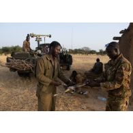 Des soldats maliens préparent le repas du soir lors d'un bivouac dans la région de Ménaka, au Mali.