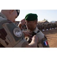 Le représentant du commandant de la force Barkhane (REPCOMANFOR) remet la croix de la valeur militaire avec étoile de bronze à un sergent du 2e régiment étranger de parachutistes (2e REP) à Gao, au Mali.