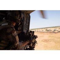 Un membre opérationnel de soute (MOS) du 5e régiment d'hélicoptères de combat (5e RHC) sécurise le périmètre en portière d'un hélicoptère Caïman NH-90 à Gao, au Mali.