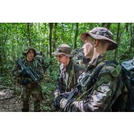 Des soldats du 7e bataillon de chasseurs alpins (BCA) font un point de situation lors d'une progression en forêt à Maripasoula, en Guyane française.