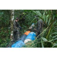 Des soldats du 7e bataillon de chasseurs alpins (BCA) découvrent un bidon sur un site d'orpaillage clandestin à Maripasoula, en Guyane française.