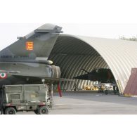 Déploiement de l'opération de la force européenne EUFOR Tchad/RCA (République centrafricaine) : un avion de chasse Dassault Mirage F1 est au parking sous un hangar sur la base aérienne 172 sergent-chef Adji Kosseï à N'Djamena. Au premier plan, l'empennage d'un avion de chasse Dassault Mirage F1-CT du régiment de chasse 2/30 Normandie-Niemen.