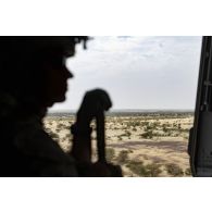 Un soldat des forces spéciales se tient en fenêtre d'un hélicoptère Caïman NH-90 entre Ménaka et Gao, au Mali.