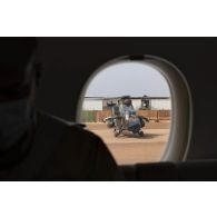Vue d'un hélicoptère Tigre EC-665 en stationnement depuis le hublot d'un avion Falcon 7X à Gao, au Mali.