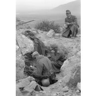 Des opérateurs radio travaillent à l'abri d'un creux dans les rochers, au sommet d'une colline.