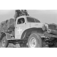 Deux soldats manoeuvrent un treuil installé sur un camion Dodge T215 d'origine américaine.