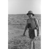Portrait d'un officier allemand, qui marche, torse nu, dans le désert.