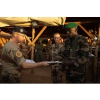 Le colonel Didier Marcel du 8e régiment du matériel (8e RMAT) remet un diplôme à un soldat malien à Gao, au Mali.