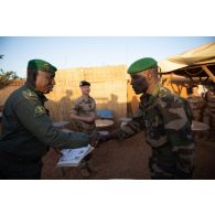 Le colonel Seydou Noumoutié Koné remet un diplôme à un soldat en présence du colonel Didier Marcel du 8e régiment du matériel (8e RMAT) à Gao, au Mali.