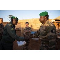 Le colonel Seydou Noumoutié Koné remet un diplôme à un soldat en présence des colonels Thibaut Lermerle et Didier Marcel à Gao, au Mali.