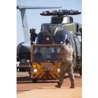 Tractage d'un hélicoptère danois Merlin EH 101 d'un avion-cargo Douglas C-17 britannique sur la piste de Gao, au Mali.