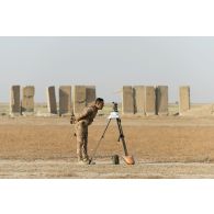 Un artilleur irakien observe le terrain au moyen d'un théodolite à Besmayah, en Irak.