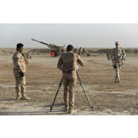 Un artilleur irakien observe le terrain au moyen d'un théodolite à Besmayah, en Irak.