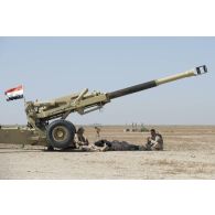 Des artilleurs irakiens se reposent à l'ombre de leur canon sur le champ de tir de Besmayah, en Irak.