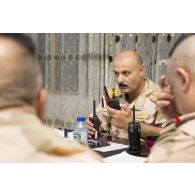 Le colonel irakien Sulaiman communique par radio avec ses unités sur le terrain depuis le centre opérationnel de la 54e brigade à Bagdad, en Irak.