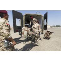 Des infirmiers irakiens évacuent un soldat blessé par ambulance à Bagdad, en Irak.