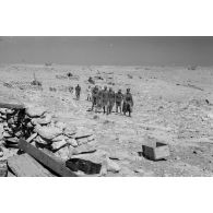 Le général Erwin Rommel suivi d'officiers italiens et allemands au milieu de la position d'artillerie italienne abandonnée.