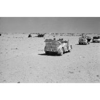 Des voitures Kfz-15, Kfz-21 et Kfz-3 qui composent l'état-major de Rommel près d'un camp et de canons italiens.